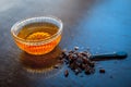 Close up of raw honey in a glass bowl on wooden surface along with powdered rock slat in a black colored spoon.Helps in getting go