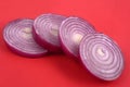 Red onion rings cut in close-up on red  background Royalty Free Stock Photo