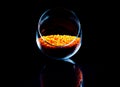 Close up of Raw Masur dal or masoor lentils or pink lentils in a black colored clay bowl on black in wineglass glass jar bucket Royalty Free Stock Photo