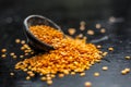 Close up of Raw Masur dal or masoor lentils or pink lentils in a black colored clay bowl on wooden surface. Royalty Free Stock Photo