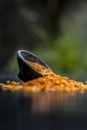 Close up of Raw Masur dal or masoor lentils or pink lentils in a black colored clay bowl on wooden surface. Royalty Free Stock Photo