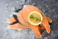 Close up of raw salmon fish fillet and ice - Fresh raw salmon steak with herbs rosemary on black plate background Royalty Free Stock Photo