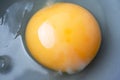 Close-up raw uncooked egg in gray bowl, top view. Macro yellow egg yolk and liquid egg whites with selective focus Royalty Free Stock Photo