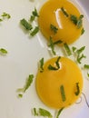 Close-up of raw uncooked egg yolks sprinkled with chopped mint leaves