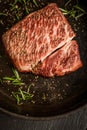 Close up raw wagyu beef striploin steak with pepper on dark pan. Restaurant Royalty Free Stock Photo