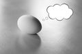 close-up of real egg with a cartoon speech bubble isolated on a table Royalty Free Stock Photo