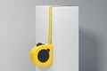 Close up of realistic yellow measure ruler on white cube. 3d rendering,