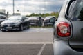 Close-up of the rear lamp of a car parked with a blurry image of the other cars in a public place Royalty Free Stock Photo