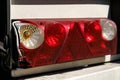 Close-up of the rear light of a truck semi-trailer with a damaged body. Royalty Free Stock Photo