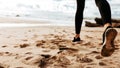 Close up rear view of female feet, lady running on sand, having morning workout on beach of ocean, panorama, free space Royalty Free Stock Photo