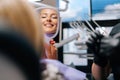 Close-up rear view of happy blonde young woman patient smiling into mirror looking at healthy white teeth enjoying Royalty Free Stock Photo
