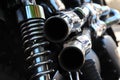 Close up rear view of a powerful classic black vintage motorcycle showing suspension and shiny chrome exhaust pipes Royalty Free Stock Photo