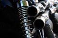 Close up rear view of a powerful classic black vintage motorcycle showing suspension and shiny chrome exhaust pipes Royalty Free Stock Photo