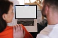 Close-up rear view shot of couple using laptop with blank screen Royalty Free Stock Photo