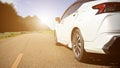 Close-up rear view of a white car with morning light with mountains and sky on the road Royalty Free Stock Photo