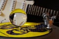 Close up of record player with yellow punk vinyl LP and crystal sphere glass ball und blurred electric guitar with black Royalty Free Stock Photo