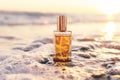 Close up of rectangular glass bottle with golden perfume washed by sea surf. Sunset light in background. Natural