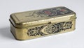 Close Up Rectangular Gold Metal Tin Box with Intricate Black Pattern and White Background Royalty Free Stock Photo