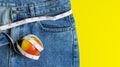 Close up of the red apple on blue jeans Wrapped around a tape measure Royalty Free Stock Photo