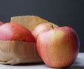 Close-up of red apples sitting on a brown paper bag