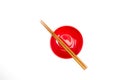 Close-up of a red bowl with wooden chopsticks on isolated background Royalty Free Stock Photo