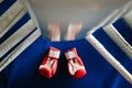 Close-up of red boxing gloves on the floor of a blue boxing ring Royalty Free Stock Photo