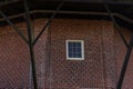 A close-up of a red brick wall in Bedum featuring a single small square white window. The wall has vertical brick pilasters and is Royalty Free Stock Photo