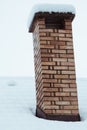 Close up on red bricked chimney on snowy rooftop Royalty Free Stock Photo