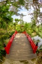 Close up of a red bridge leading over a pond in Hiroshima Japan Royalty Free Stock Photo