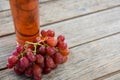 Close-up of red bunch of grapes with bottle of red wine Royalty Free Stock Photo