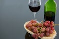 Close-up of red bunch of grapes with glass and bottle of red wine Royalty Free Stock Photo