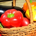 Close up of red capcicum and other fresh vegetables in a wicker basket Royalty Free Stock Photo