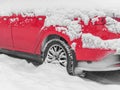 Close-up red car under the snow. Snowfall, bad weather winter concept Royalty Free Stock Photo