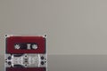 Close up of red cassette tape on grey background with reflection Royalty Free Stock Photo