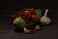 Cherry tomatoes, zucchini, chili and garlic close-up on a dark mat. Royalty Free Stock Photo