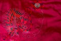 CLose-up of a red Chinese silk embroidered dragon pattern