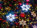 Close up of red christmas balls, snow flakes and golden garland night street lights on Chrismas tree. Bokeh garlands Royalty Free Stock Photo