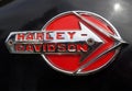 close up of a red and chrome harley davidson logo on the tank of a black motorcycle