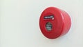 Close-up of red circular fire alarm with manual switch button