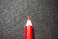 Close up of a red coloured pencil colour, with black background.