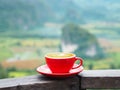 Close up red cup of latte coffee over blurry mountain background Royalty Free Stock Photo