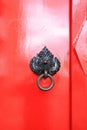 Close up red door - Freshly painted red front door with mythical creature head bronze knocker