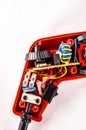 A close up of a red electrical device with wires and a yellow and blue component Royalty Free Stock Photo