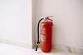 Barcelona, Spain - 12 may 2020: A close-up of a red fire extinguisher on the floor in the corner against a white wall. Royalty Free Stock Photo