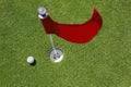 Red flag on green with golf ball. Royalty Free Stock Photo