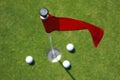 Red flag on green with golf balls. Royalty Free Stock Photo