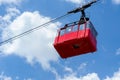 Close up of red funicular in sky. Old waggon moves along cable car in sunny weather. Royalty Free Stock Photo