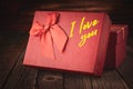 Close up of a red gift box with the words I love you on a wooden background: concept of a festive and romantic gift Royalty Free Stock Photo