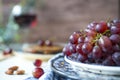 Bunch red grapes in blue  bowl, against brown blur background. Royalty Free Stock Photo