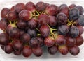 close up of red grapes in plastic bowl, top view of grape fruits in transparent packaging